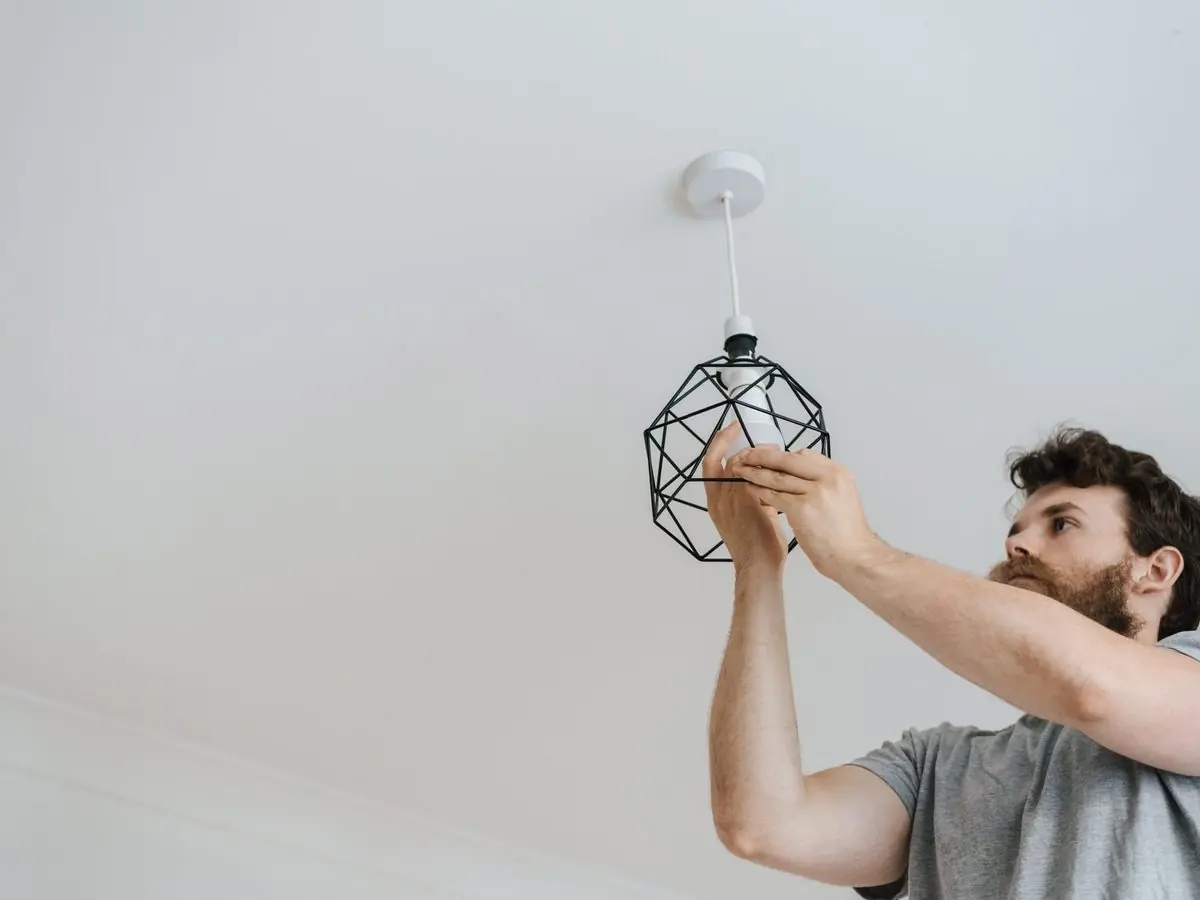 Un électricien installe un luminaire